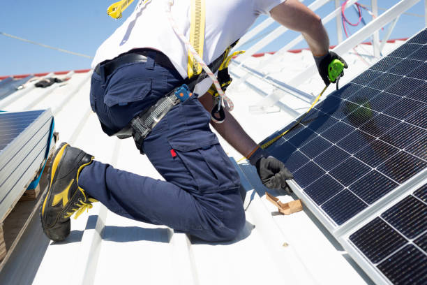 A worker measures solar panels with a meter to install them on the rooftop